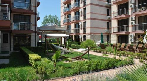 a garden with a hammock in front of a building at Apartment Privat in Sunny Beach in Sunny Beach