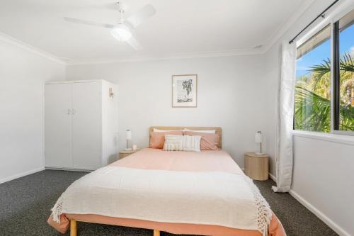 a bedroom with a large bed and a window at Beach Shack No. 6 in Crescent Head