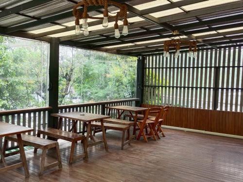 a porch with wooden tables and chairs on a deck at Sukhum Rajamangala-Phatthanakan Rooms in Bangkok