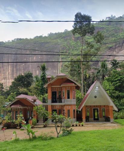 a large house in the middle of a field at Kenzona Homestay in Andalas