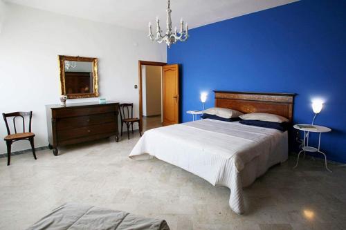 a bedroom with a large bed and a blue wall at Smile House in Matera