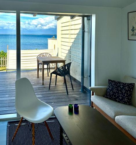 a living room with a couch and a table on a deck at Beach House In Ålsgårde in Ålsgårde