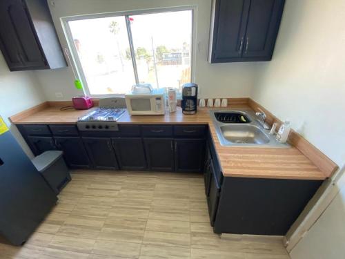 a small kitchen with a sink and a microwave at Family Apartment & Free Parking! in Rosarito Beach