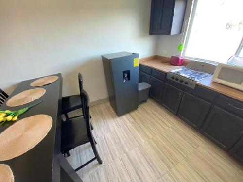 a small kitchen with a table and a refrigerator at Family Apartment & Free Parking! in Rosarito Beach