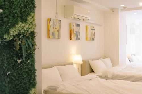 東京にあるPenthouse 8min walk to Shibuya Staの緑の壁の客室で、ベッド2台が備わります。
