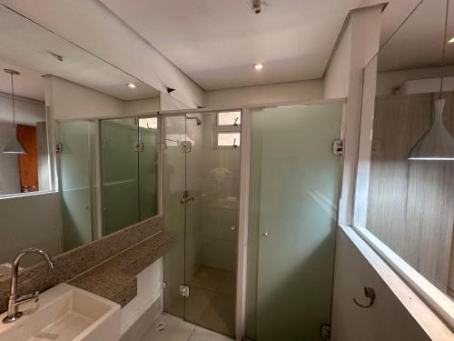 a bathroom with a glass shower and a sink at Vila mangaba in São José dos Campos