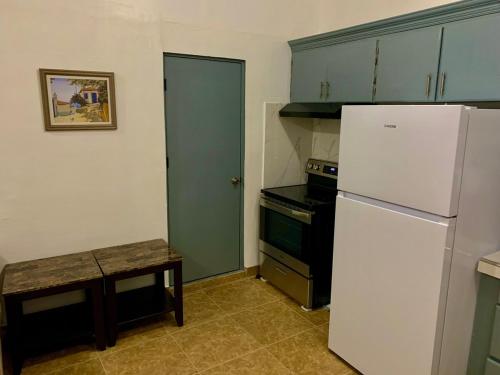 a kitchen with a white refrigerator and a table at Pedro's Heights 2 Bed, 1 Bath in Tumon