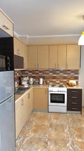 a kitchen with wooden cabinets and a white stove top oven at Anesis home in Gythio