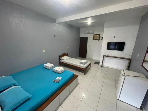 a large room with a blue bed and a couch at Hotel Torre Forte in Careiro