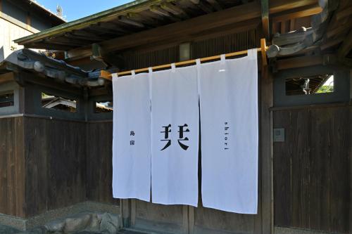 a group of white towels hanging on a building at 島宿栞 in Tonosho