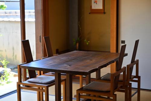 a wooden table and chairs in a room at 島宿栞 in Tonosho