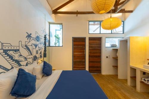 a bedroom with a large bed with blue pillows at Santorini Suites Canggu in Canggu