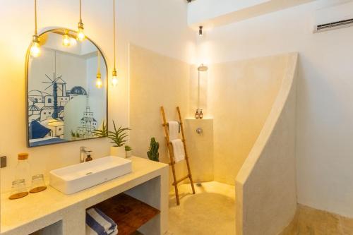 a bathroom with a sink and a mirror at Santorini Suites Canggu in Canggu