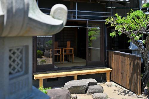 a house with a bench in front of a window at 島宿栞 in Tonosho