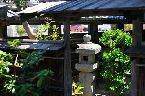 a stone bird feeder in a garden at 島宿栞 in Tonosho
