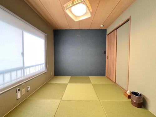 an empty room with a large window and green floor at Aoi Garden Takayama 5 minutes walk from Takayama Station Japanese modern style garden view in Takayama