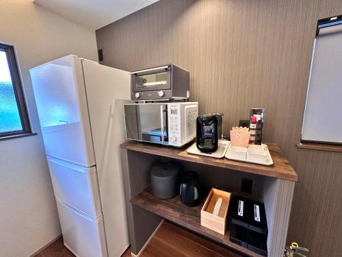 a kitchen with a microwave and a refrigerator at Aoi Garden Takayama 5 minutes walk from Takayama Station Japanese modern style garden view in Takayama