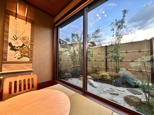 a room with a large window looking out at a garden at Aoi Garden Takayama 5 minutes walk from Takayama Station Japanese modern style garden view in Takayama