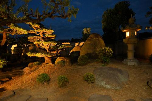 a garden at night with a tree and a light at 島宿栞 in Tonosho