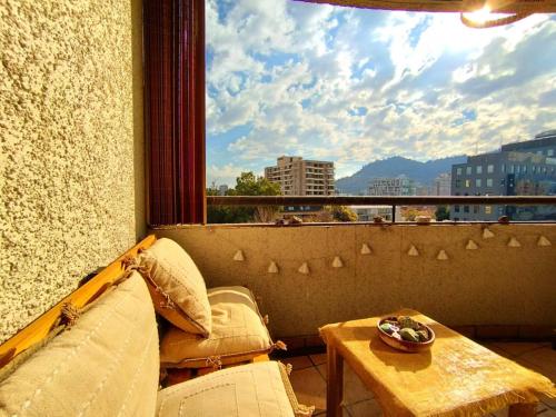 a balcony with a table and a large window at Departamento Providencia, vista a San Cristóbal in Santiago
