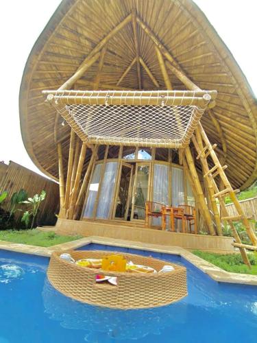 a round house with a pool in front of it at Hidden Bamboo Village in Selat