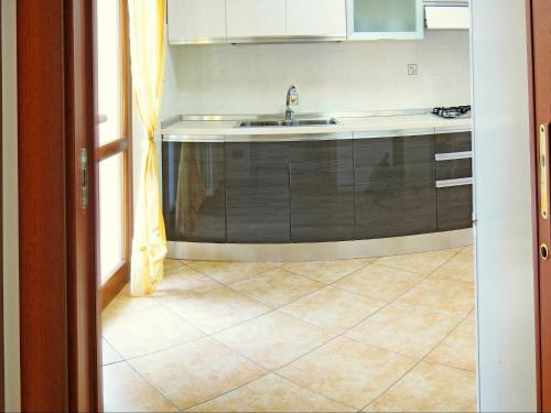 a kitchen with a sink and a tiled floor at Holiday Home Bardolino with Pool near Lake in Bardolino