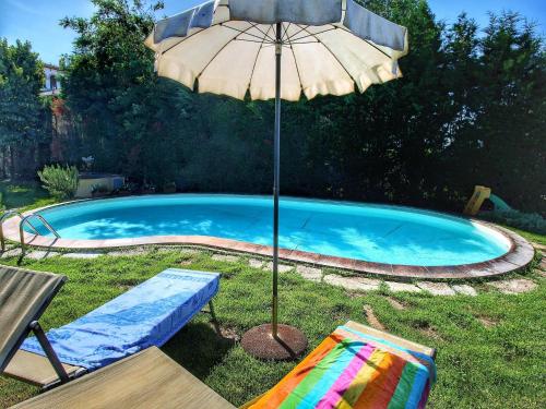 a pool with an umbrella and a bench and a chair with at Attractive mansion with pool in Cignano