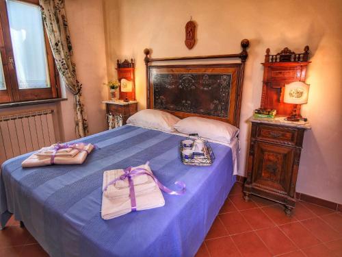 a bedroom with a blue bed with two bags on it at Attractive mansion with pool in Cignano