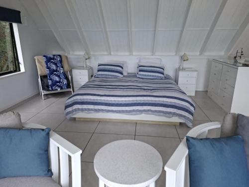 a bedroom with a bed with blue and white pillows at Rangimarie Anaura Bay Beachstay in Anaura Bay
