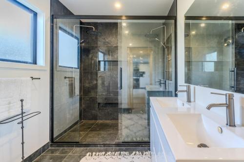 Un baño con dos lavabos y una ducha. en Harbour Retreat at St Leonard's, en Dunedin