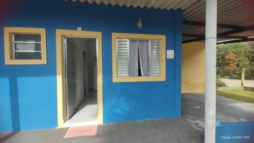 a blue wall with two windows on a house at Kitnet a 200m da Praia, Boqueirão Sul, Balsa Cananéia, Ilha Comprida in Ilha Comprida