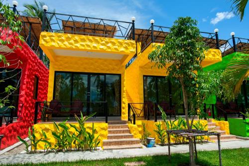 a yellow house with a staircase in front of it at Irak Resort Ao Manao  in Klong Wan