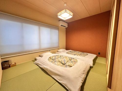a hospital room with two beds and a large window at Aoi Garden Takayama 5 minutes walk from Takayama Station Japanese modern style garden view in Takayama