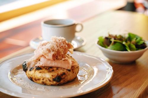 a plate with a pastry on a table with a cup of coffee at SOIL Nihonbashi Hotel in Tokyo