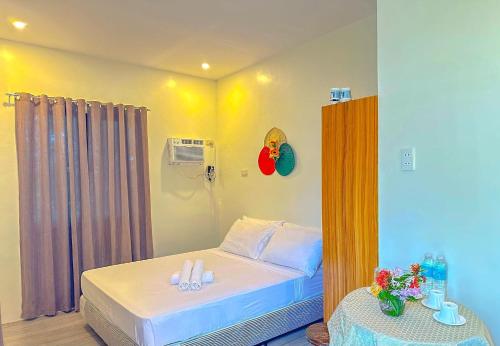 a small bedroom with a bed and a table at RDM Beach Resort in General Luna