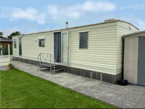a green and white mobile home with a patio at Auw Farm Life Escape in Auw