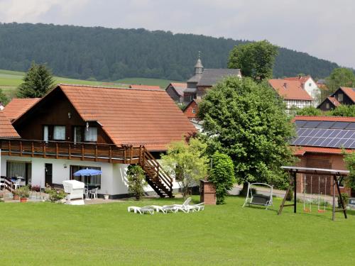 a house with a yard with chairs in the grass at Apartment in Armsfeld mit Pool 