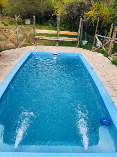 a pool of blue water in front of a fence at La Polcura Lodge Turismo -Fishing Lodge & Spa in El Llano