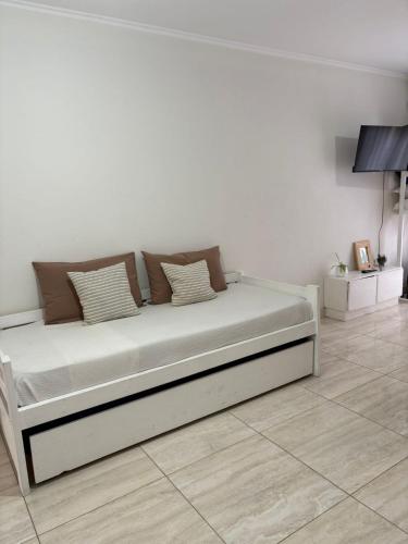 チビルコイにあるVento Apartの白い壁のドミトリールームのベッド1台分です。