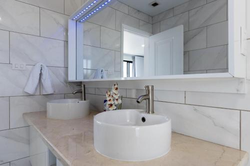 a white bathroom with a sink and a mirror at Perla 8- Exclusiva Moderna Villa 4 Habitaciones y Piscina in Sosúa