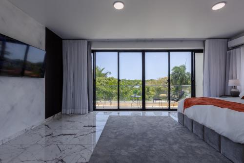 a bedroom with a bed and a large window at Perla 8- Exclusiva Moderna Villa 4 Habitaciones y Piscina in Sosúa