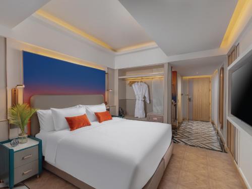 a bedroom with a large white bed and a television at Pipa Hotel Bangkok Sukhumvit 11 in Bangkok