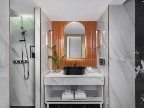 a bathroom with a sink and a mirror at Pipa Hotel Bangkok Sukhumvit 11 in Bangkok