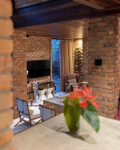 a living room with a table and a fireplace at Casa da Pedra Serrinha in Resende