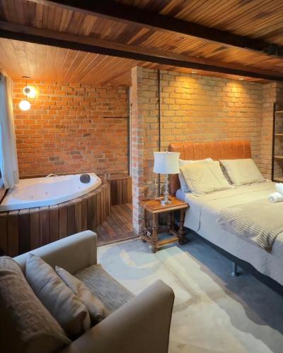 a bedroom with a bed and a bath tub at Casa da Pedra Serrinha in Resende