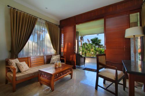 a living room with a couch and a table at Amarta Beach Retreat by Nakula in Tabanan