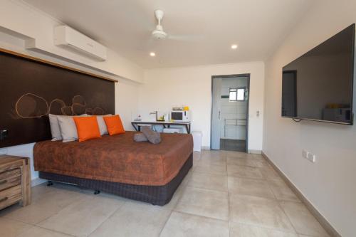 a bedroom with a large bed with orange pillows at Safari Lodge Motel in Tennant Creek