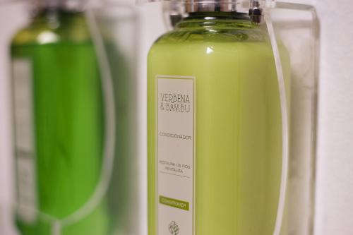 a bottle of green liquid sitting next to two other bottles at Beijo do Vento Pousada in Arraial d'Ajuda