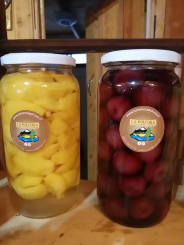 two mason jars filled with fruit on a table at La Polcura Lodge Turismo -Fishing Lodge & Spa in El Llano