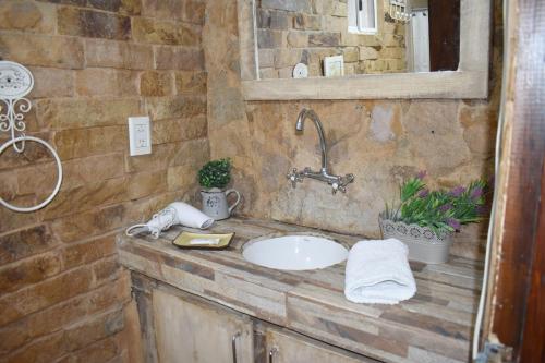 a stone bathroom with a sink and a mirror at Hotel Cabañas Aparts Tierra de Glaciares in El Calafate